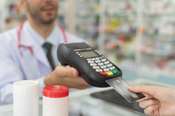 Customer woman paying by credit with NFC technology, holding credit card with terminal screen. Hand of customer using credit card with payment machine. Pay by credit card. Pay online concept