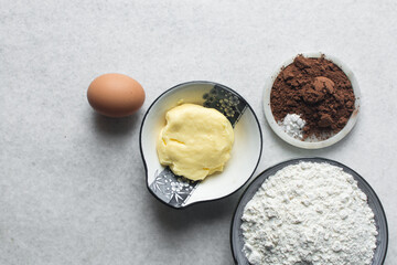 Overhead view of ingredients for making chocolate cookies, top view of mise en place of ingredients for making chocolate sugar cookies, process of making chocolate cookies