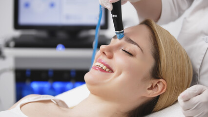 A professional cosmetologist performs hydropeeling and hydrafacial on the client, providing...