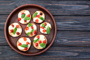 Italian mini pizza . Aubergine (eggplant ) with mozzarella cheese and basil . On rustic background