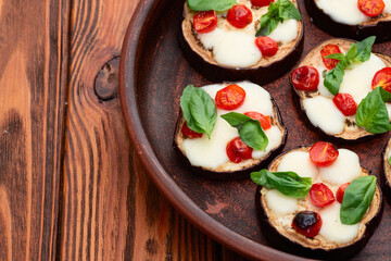 Italian mini pizza . Aubergine (eggplant ) with mozzarella cheese and basil . On rustic background