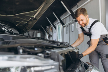 Auto Mechanic Replacing Car Headlight in Modern Repair Shop Garage