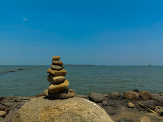 Balanced Stone Cairn by the Sea Reflecting Tranquility in a Calm Coastal Landscape