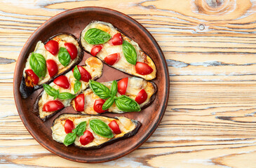 Italian mini pizza . Aubergine (eggplant ) with mozzarella cheese and basil . On rustic background