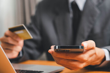 Close up Male hands holding credit card and smartphone, man paying online, credit card shopping, using banking service, entering information, shopping, ordering in internet store, doing secure payment