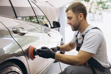 Professional Car Detailing with an Auto Polisher in a Garage Setting