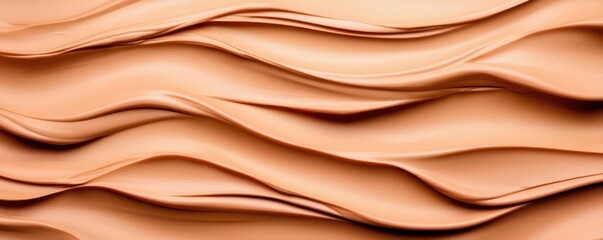 Obraz premium A smooth, wavy texture of peach-colored material, ideal for backgrounds, design elements, or creative projects.