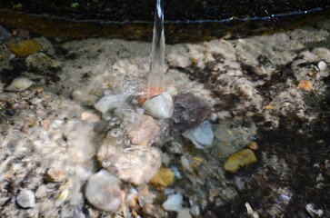 clean transparent spring water flowing over the stones