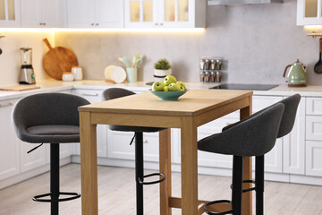Bar stools near table in stylish kitchen