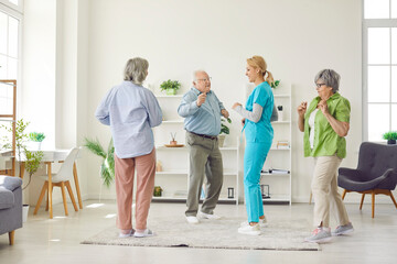 A group of elderly people and a nurse dance joyfully in a boarding house. Leisure concept in a...