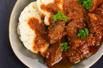 Beef goulash and dumplings (knedliky) on table