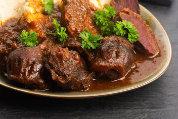 Stewed goose stomach.  Traditional Polish meat on a dark background.