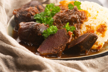 Stewed goose stomach.  Traditional Polish meat on a dark background.