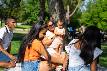 Young multigenerational Latin family having picnic in a park