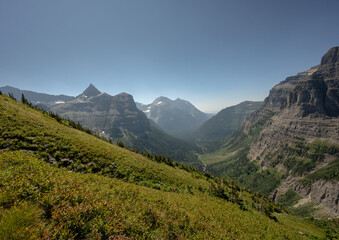 Obraz premium Bowman Creek Runs At The Bottom Of The Valley Below Thunderbird Mountain and Boulder Pass