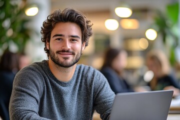 Fototapeta premium Young professional working on laptop in a casual office environment, concept of remote work, entrepreneurship, and modern business lifestyle 
