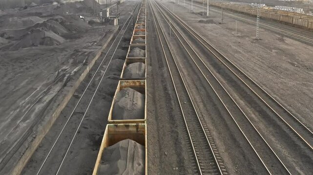 Railway station for loading coal. Wagons of freight train aerial view. Cargo freighter wagons. Coal mine railway, thermal power plant transport hub. Infrastructure serving coal mining. Coal production