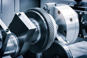 A gear is being worked on with a tool. Concept of precision and focus as the worker carefully manipulates the gear