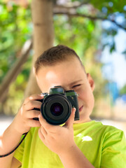 Little boy with a digital camera. Young photographer during a shoot. The boy is taking pictures with a camera