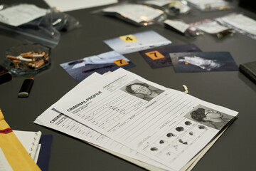 Various pieces of evidence and files spread on table during criminal investigation process....