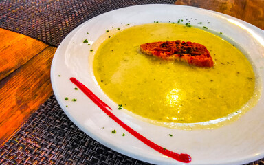 Potato cream soup a piece of bread and greens Mexico.