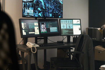 Naklejka premium Office space having multiple computer monitors displaying security footage and detailed information. Room filled with equipment and work essentials indicating active surveillance