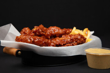 Delicious Crispy Chicken Tenders, Perfect for Any Meal. A close-up of a basket of crispy chicken tenders, served with golden brown fries and a side of dipping sauce.