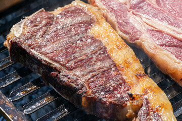 old cow steak cooking on the grill