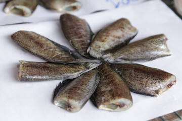 Dried gourami fish arranged in a circle on paper. Dried gourami is a method of food preservation that has been around since ancient times.