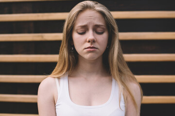 Concept of cheerless and joyless, disappointed hipster girl feeling sad and melancholy while...