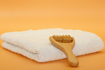 Massageroller aus Holz auf weißem Handtuch freigestellt