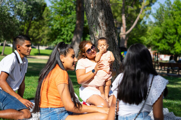Family reunion having a picnic outdoors. Latin family