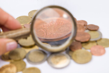 Coins in glass with a magnifying glass. Selective focus.