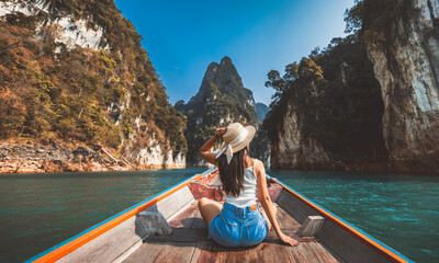 Traveler asian woman relax and travel on Thai longtail boat in Ratchaprapha Dam at Khao Sok National Park Surat Thani Thailand