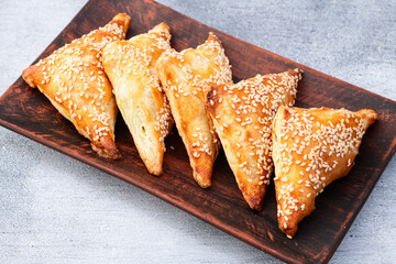 Homemade triangle puff pastry with meat on rustic background . Samosa