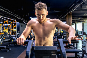 Athlete doing exercises on an air bike exercise bike close-up.