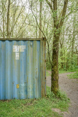 Blue container in a green forest setting