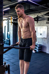 Fototapeta premium Ahlete doing push-ups in the gym with a bare torso. Sport lifestyle.