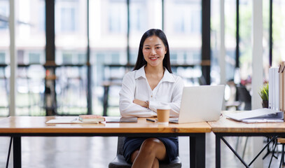 Asian Businesswoman Using laptop computer and working at office with calculator document on desk, doing planning analyzing the financial report, business plan investment, finance analysis concept.
