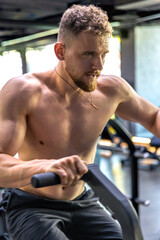Obraz premium Athlete doing exercises on an air bike exercise bike close-up.
