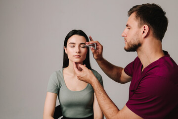 Blepharoplasty marking up. Plastic surgeon is measuring distance in between marking lines for well planned blepharoplasty. Using Castroviejo caliper to draw symmetrical contour for eyelid surgery.