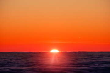 Scenic view of sun rising over clouds horizon, vivid colorful skyline