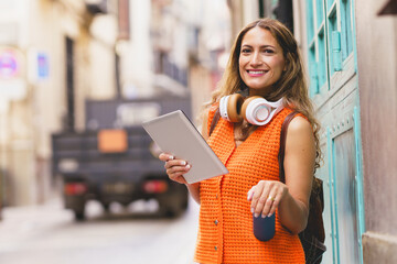 Student holding reusable water bottle while using digital tablet