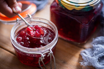 Gooseberry jam in a glass jar on a wooden table. Gooseberry jam in a glass jar. Close-up