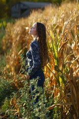 A Serene Young Woman Enjoying the Beauty of a Cornfield During a Vibrant Sunset Scene