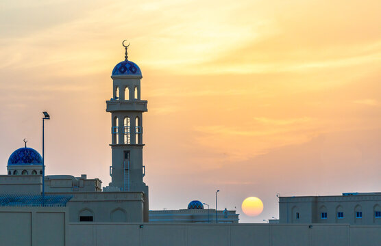 Beautiful sunset over the mosque with ornated blue domes and minarets, Ibri, Sultanate Oman