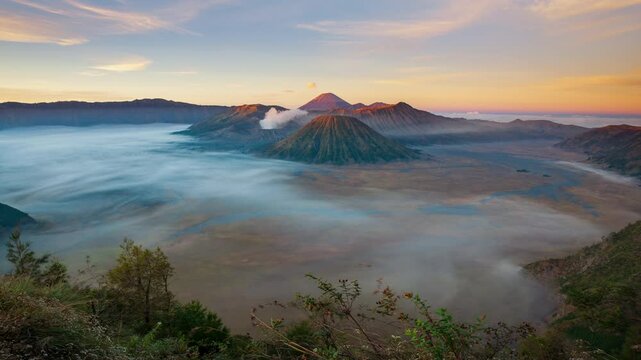 Timelapse mount Bromo active volcano with smoke coming out of main crater during sunrise, Java, Indonesia 
