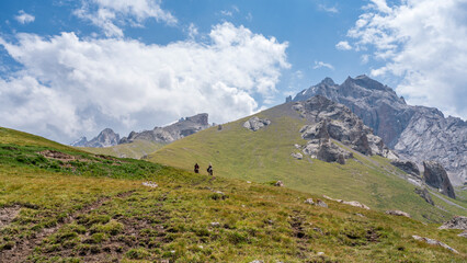 Fototapeta premium Tourists are going to Kel-suu lake on horses 