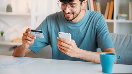Mobile bank. Online payment. Electronic money transaction. Happy satisfied smiling guy using credit...