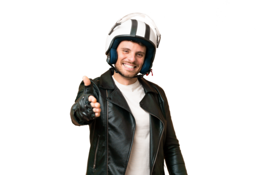 Brazilian man with a motorcycle helmet over isolated chroma key background shaking hands for closing a good deal